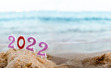 Figures 2022 against background of coastal . Travel during quarantine on New Year's Eve, before arrival of new year. Celebrating the 2021 departure on beach during the Christmas holiday.