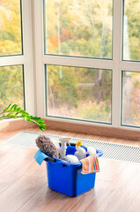 House cleaner on wooden floor on window background
