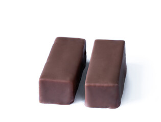 a pair of souffle candy in chocolate with vanilla and fillings isolated on white background