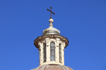 Fototapeta na wymiar Santa Maria del Popolo Church Dome Lantern Against a Blue Sky at Piazza del Popolo Square in Rome, Italy