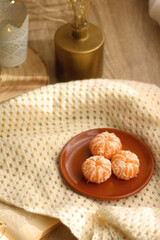 Peeled tangerines, butternut squash, open book, reading glasses and cozy blanklet. Hygge at home. Selective focus.