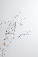 christmas  branches with golden and white  balls on white wall background