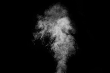 Fragment of white hot curly steam smoke isolated on a black background, close-up.Abstract...
