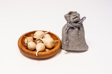 Obraz na płótnie Canvas Garlic in a wooden saucer and a canvas bag.