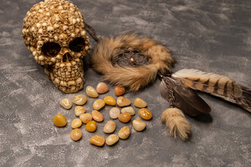 Stones with the sign of the zodiac. The concept of horoscopes and fortune-telling. Magic stones. Astrology and esoterism. Stone runes and pouch on concrete gray background. Top table view and close-up