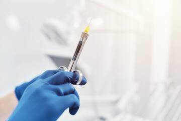 
a dentist holds a dental syringe in a dental clinic - obrazy, fototapety, plakaty