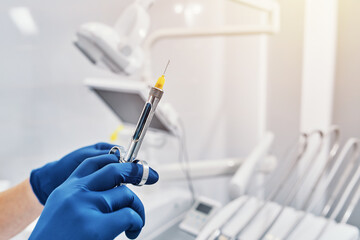 
a dentist holds a dental syringe in a dental clinic