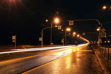 Night city road, street light, pedestrian crossing and wet asphalt 