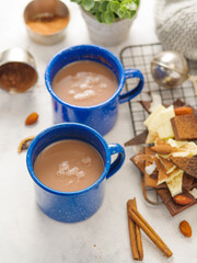 Breakfast table for two. Coffee in two blue cups, a lot of sweets, decor on a white background. Romantic date, married couple, Valentine's Day, Christmas, New Year, holidays.
