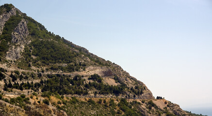 Fototapeta na wymiar Góra stok porośnięty roślinnością i oplatającymi ją drogami prowadzącymi na szczyt