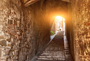 Perugia, Umbria, Italy. August 2021. A charming alley with arched vaults leads us up a staircase in the heart of the historic center.