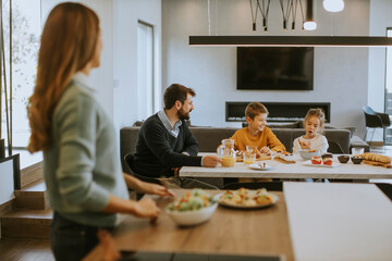 Young mother preparing breakfast for her family in the kitchen