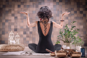 Image of an adult woman in yoga place. Meditation. Back view. The concept of yoga and spiritual...