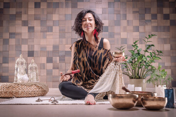Image of an adult woman in yoga place. Playing on Tibetan singing bowls. The concept of yoga and...