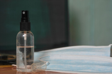 Obraz na płótnie Canvas hand sanitizer bottle and medical masks on a table