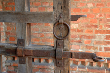 Antique gate with latch on red brick wall