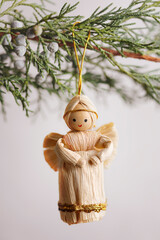 Handmade straw angel hanging on pine tree
