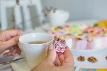 Turkish Delight on the white kitchen on the white table with cup of tea and dry flowers