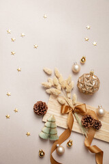 Stimmungsvolles, natürliches Weihnachtsarrangement mit Trockenblumen, Kugeln, Sternen, Zapfen, Schleife und Weihnachtsdekoration auf Holz und Naturpapier, top View, Hochformat, Weihnachtskarte