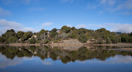 Symmetry in nature. Summer in the lake. The perfect reflection of the blue sky, green forest and mountains in the lake's water surface.