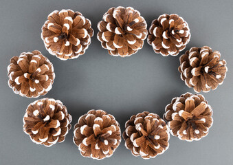 Decorative pine cones on a dark gray background, the basis for a greeting card for Christmas and new Year 2022. Top view.