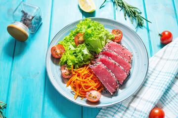 Salad with pieces of tuna and sesame with fresh vegetable salad on a plate. Authentic Japanese food