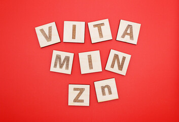 Wood cube letters Vitamin Zn on the red background