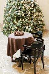 Table and chairs near Christmas tree.