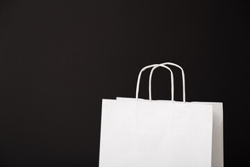 Blank white paper bag isolated on black background. Black friday, sale, discount, recycling, shopping and ecology concept.