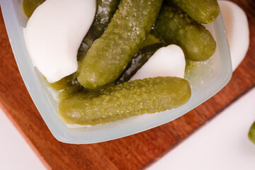 Pickles cucumbers with garlic on a white plate. Russian menu. 