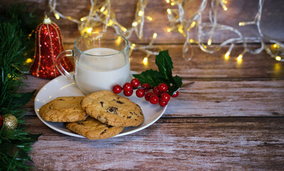 Milk with Christmas cookies for santa claus on a wooden table, selective focus