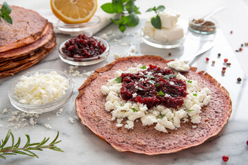 Close-up of pink pancakes with beetroot and feta, and green pancakes with spinach