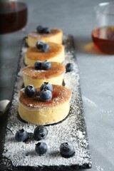 Trendy asian food, Fluffy Japanese Souffle Pancakes, Hotcakes with sugar powder , berries and tea, lightr background.