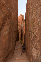 Person fooling around in a narrow gorge in the Arches National Park