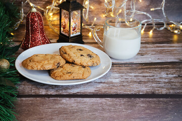 Milk with Christmas cookies for santa claus on a wooden table, selective focus