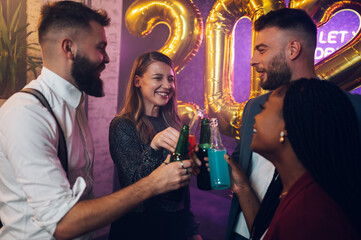 Happy group of friends celebrate New Year's Eve while dancing in the club