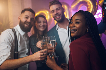Friends celebrate New Year's Eve while drinking champagne
