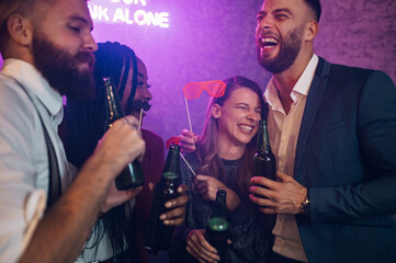 Happy group of friends dancing on a party in a club