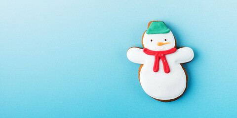 Funny snowman of gingerbread on blue gradient background Christmas banner design. Copy space.