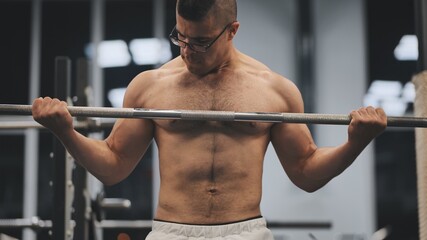 Fototapeta na wymiar Young Arab man pumping biceps in the gym.