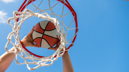 basketball ball flying through basket in players hands, copy space, targeting © Olena