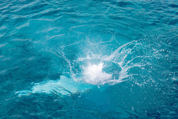 Obraz premium Splashes of blue, sea water with foam bubbles. A splash of nature on a summer day. blue sea background with splashing water. sea vacation concept.