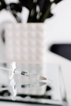 A medical syringe on mirror with reflection. Syringe with liquid inside. High quality photo