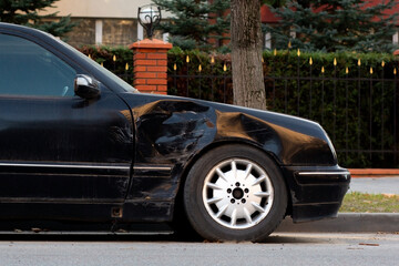 Naklejka premium Car accident, old black car after the accident parked on the road left an insured event