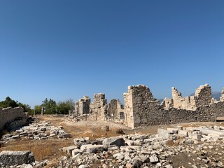Fototapeta premium Ruins of an ancient amphitheater. Roman amphitheater in Turkey.Ancient stones of the excavated historic city. Turkey, Fetiya, August 13, 2021