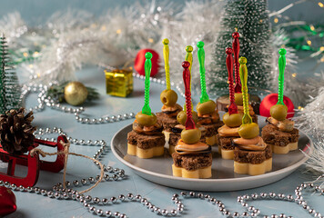 Canapes with mussels, cheese and olives: a festive bright appetizer on blue background