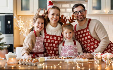 Happy family mother, father, two kids   baking Christmas cookies in kitchen
