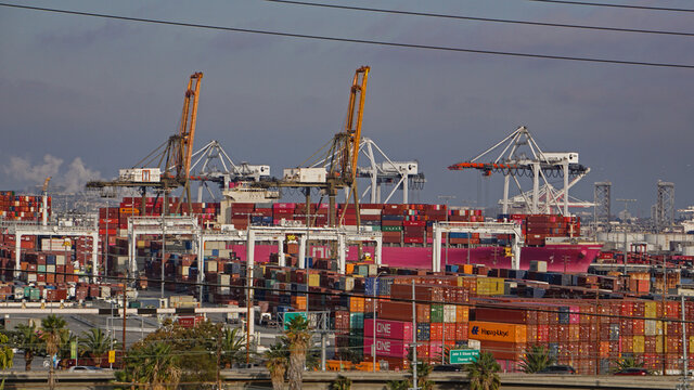 Los Angeles, California USA - November 16, 2021: A busy Port of Los Angeles container freight terminal crowded with ships, equipment and shipping containers
