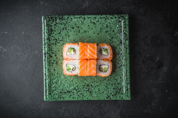sushi with salmon on a black plate