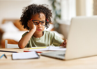 Focused african american child school boy listening attentively to teacher during online lesson